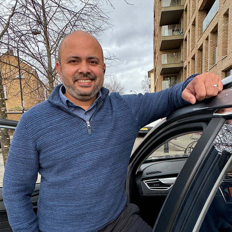 Driver smiling next to his car