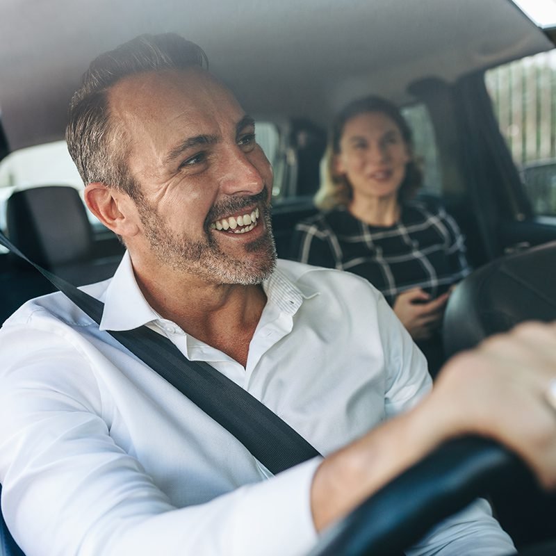 Driver%20smiling%20in%20car%20with%20passenger