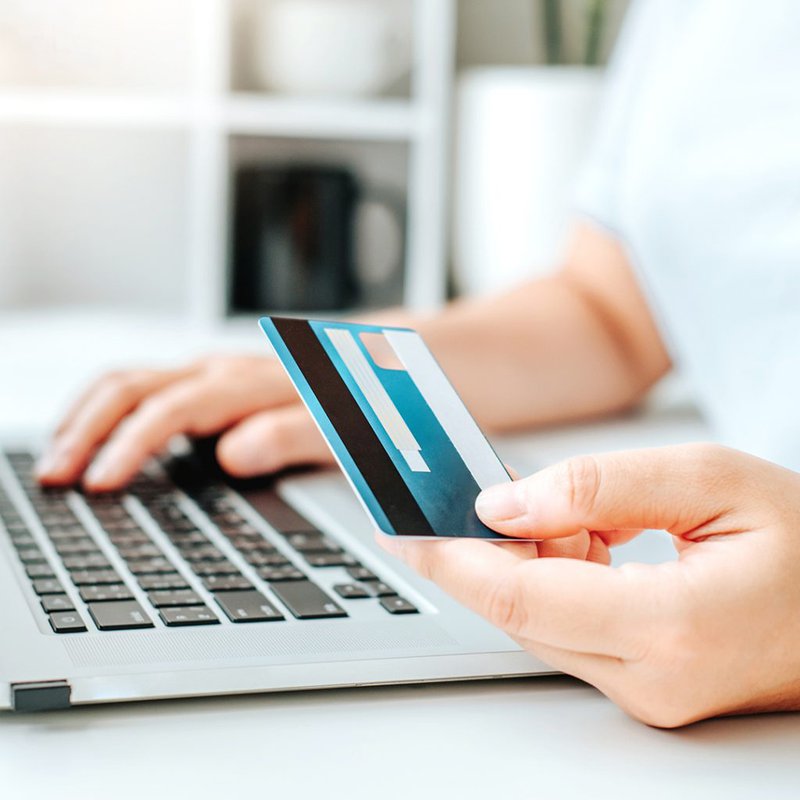 Person%20holding%20a%20bank%20card%20with%20their%20laptop%20making%20a%20payment